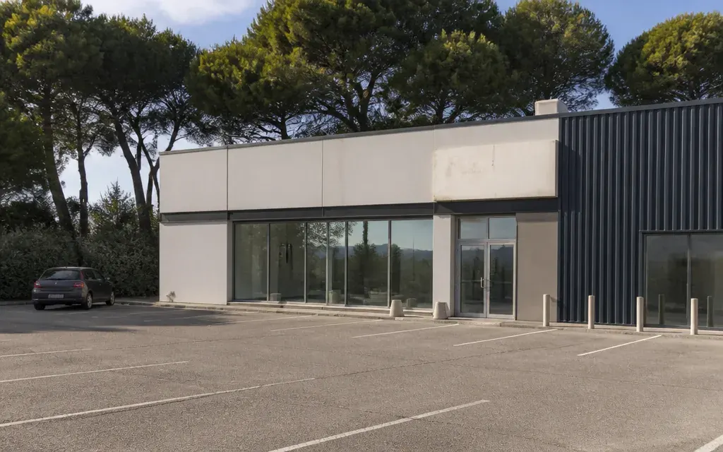 Bord de route d’activité à Bouc-Bel-Air, façade sobre d’un local commercial avec réserve attenante, parking peu…